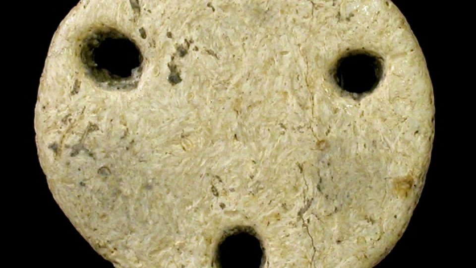 Rondel - vrtaná destička prům. 32 mm z lidské lebky. Prosmyky (o. Litoměřice) - doba laténská.