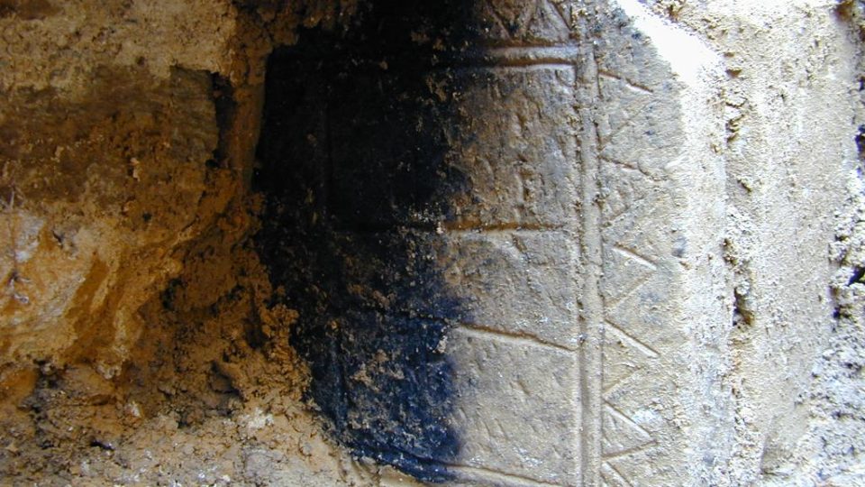 Románský johanitský náhrobní kámen druhotně zazděný v suterénu jižního křídla zámku v Českém Dubu