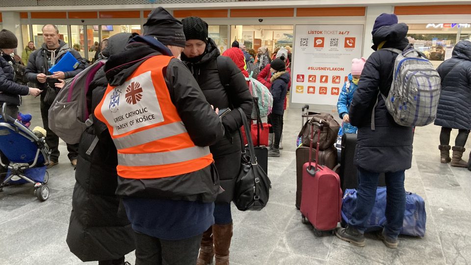 Dobrovolníci na hlavním vlakovém nádraží v Košicích pomáhají uprchlíkům najít správný spoj, vyměnit si peníze nebo najít ubytování