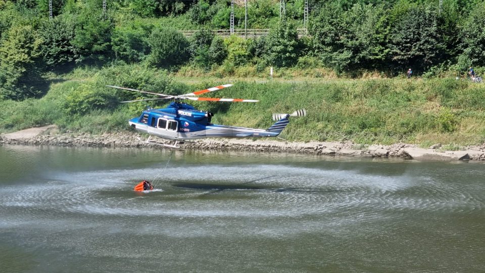 Vrtulník nabírá vodu z Labe na hašení požáru v Českém Švýcarsku