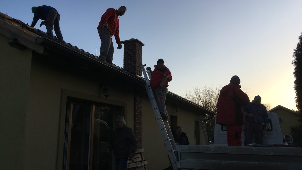 Dělníci rozebírají střechu.