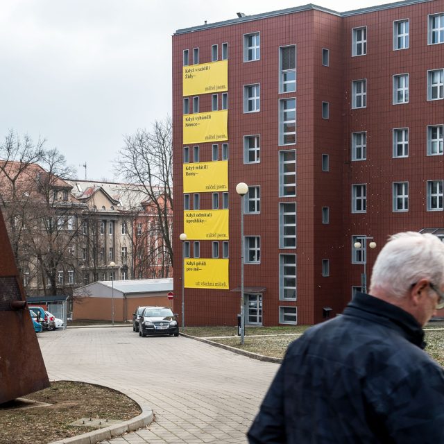 Velké žluté plakáty na tmavě červené budově Fakulty umění a designu v Ústí nad Labem | foto: Ondřej Hájek,  ČTK