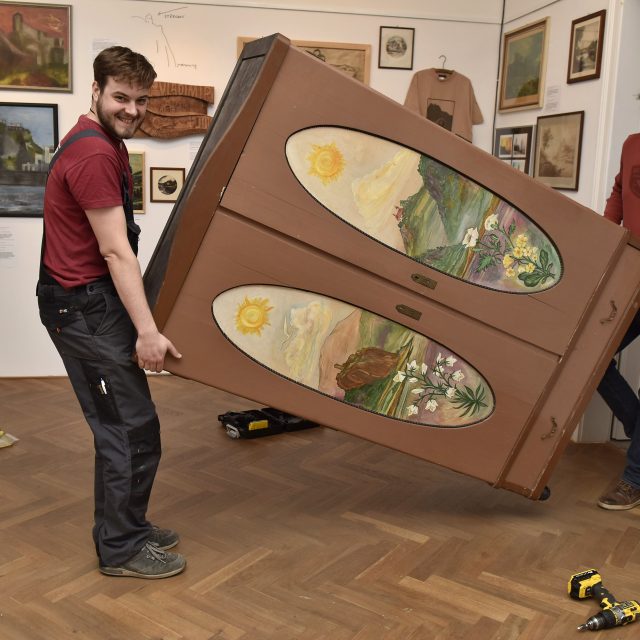 Pracovníci Muzea města Ústí nad Labem Jakub Doležel a Martin Krsek při instalaci malované skříně | foto: Muzeum města Ústí nad Labem