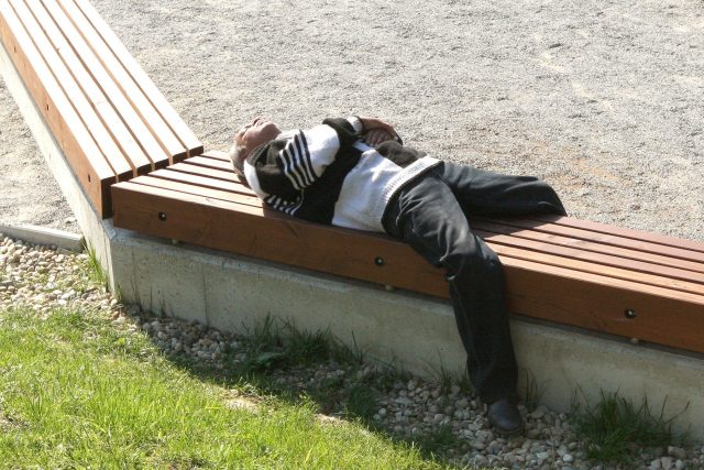 Bezdomovec spí na lavičce | foto: Profimedia