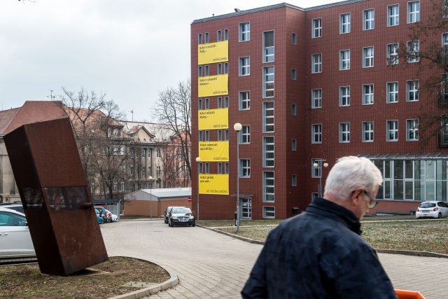 Velké žluté plakáty na tmavě červené budově Fakulty umění a designu v Ústí nad Labem | foto: Ondřej Hájek,  ČTK