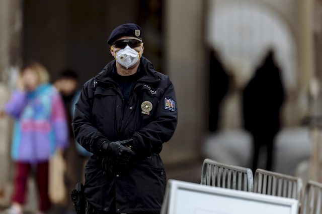 Hlídkující policista s respirátorem | foto: Petr Topič,  MAFRA / Profimedia