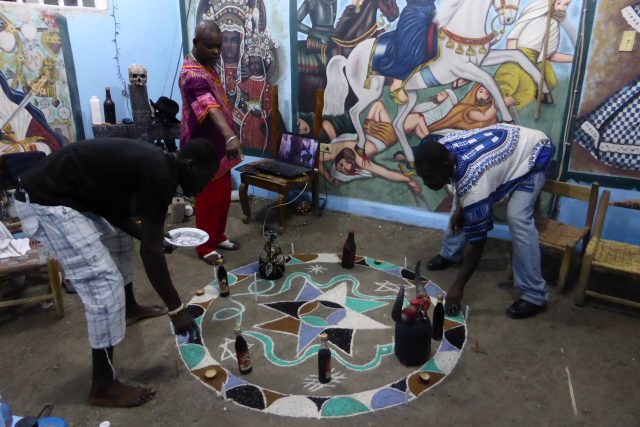 Vysypávání barevného vévé,  které jsou v kurzu v hlavním městě Haiti. Hlavní kněz přikazuje,  ostatní poslouchají | foto: Veronika Šulcová