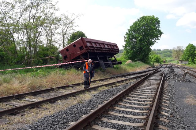 Jeden z odstavených vagónů,  který vykolejil,  stojí „našikmo“ bez kol u cesty mimo trať | foto: Libor Želinský