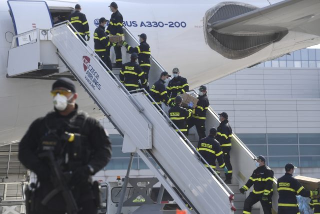 Hasiči vykládají letadlo,  které v pátek přivezlo do Čech z Číny přes milion respirátorů FFP2 | foto: Michal Kamaryt,  ČTK